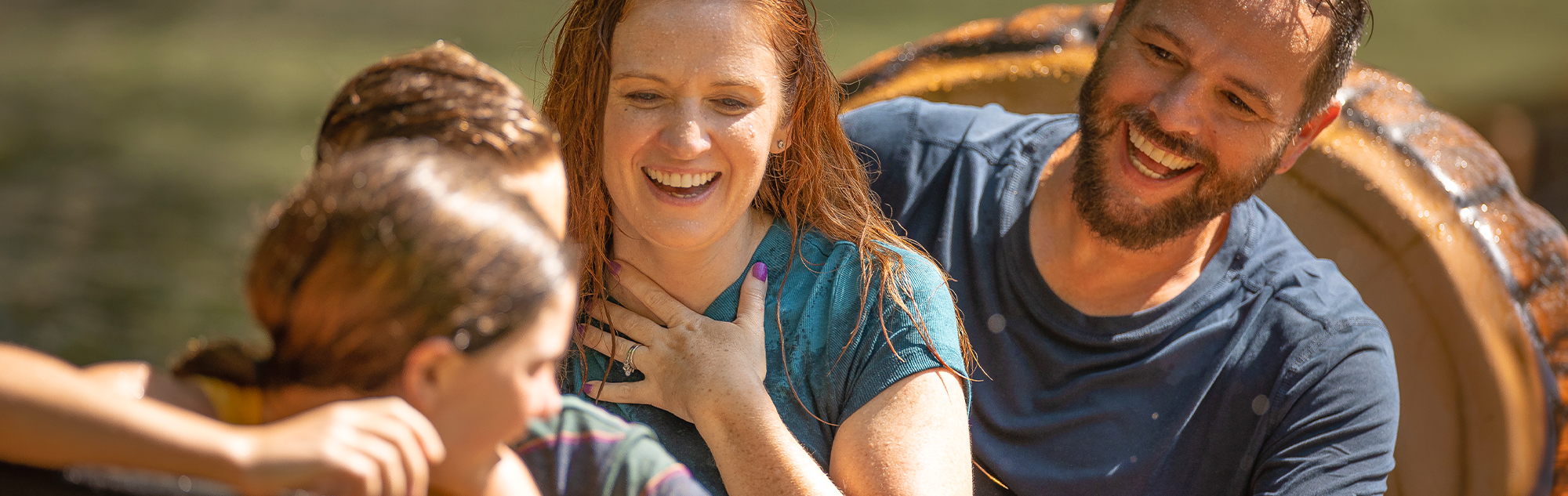 A father smiles at his two daughters after their log on Frightful Falls splashed down in the water at the end of the ride.