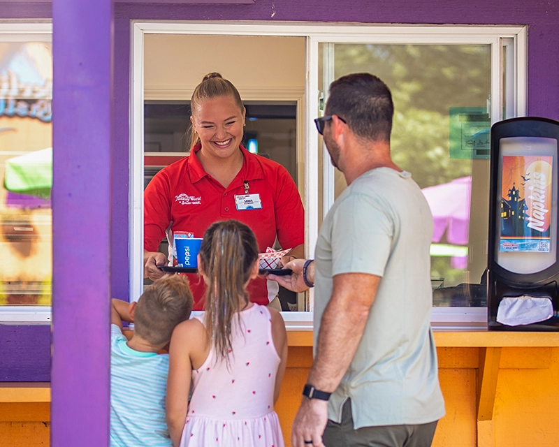A Team Member hands a family their food at Goblin Burgers.