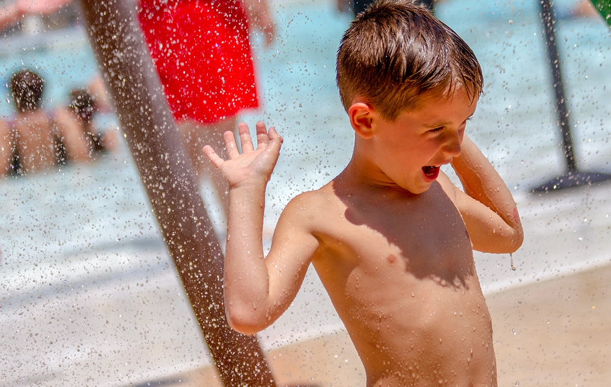 Young boy playing in the sprayground features of Safari Sam's SplashLand at Holiday World & Splashin' Safari in Santa Claus, Indiana.