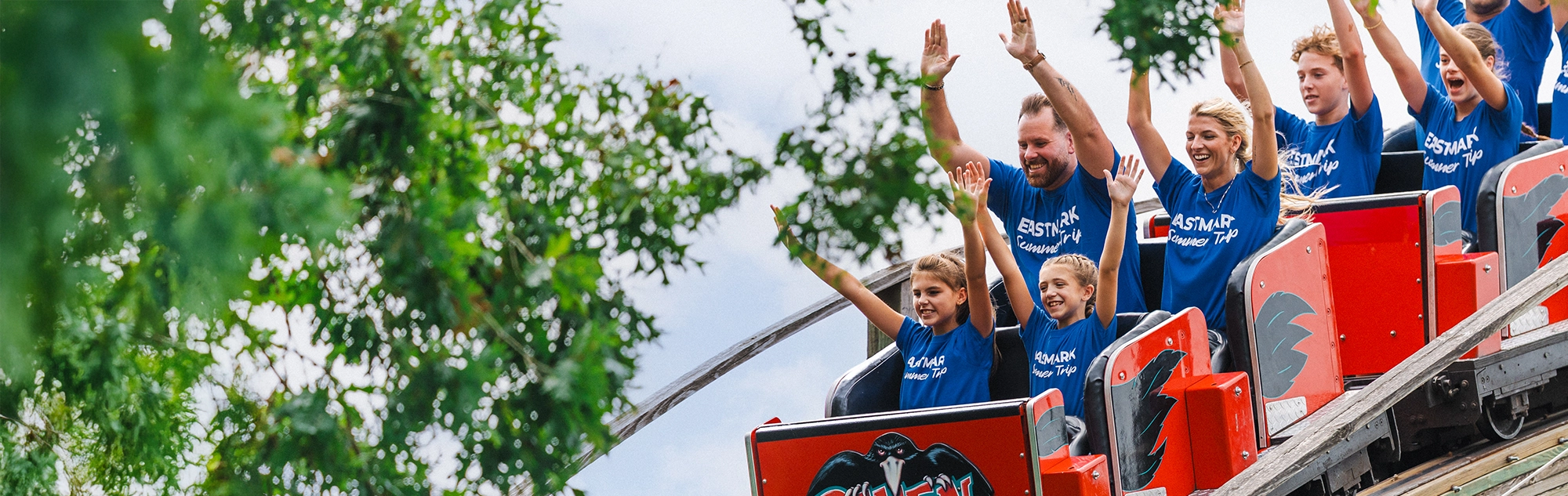 A corporate group in matching shirts riding Raven at Holiday World.